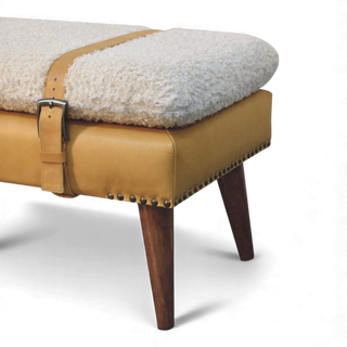 Side view of the Bouclé Bench Cream Tan Leather X-Strap showing the slim profile, leather-wrapped base, and tapered wooden legs.


