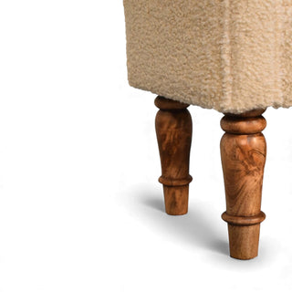 Close-up of the Bouclé Bench Cream Turned-Leg Classic showing the carved wooden turned legs against a white background.