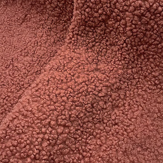 Close-up of brown teddy fabric featuring plush texture and subtle folds.