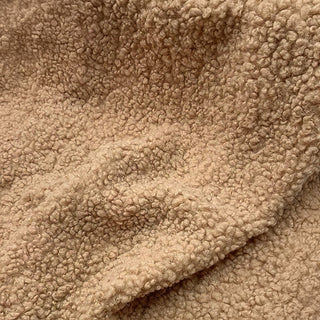 Close-up of camel teddy fabric displaying cozy, textured surface with natural draping.