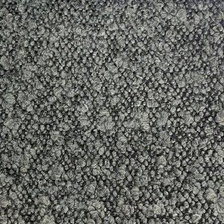 Close-up of dark grey tweed fabric displaying deep toned weave with varied flecks.