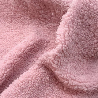 Close-up of dusty pink teddy fabric featuring plush texture and gentle waves.