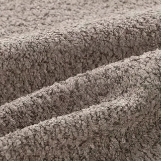 Close-up of gray bouclé fabric showing three diagonal folds, with visible nubby texture.