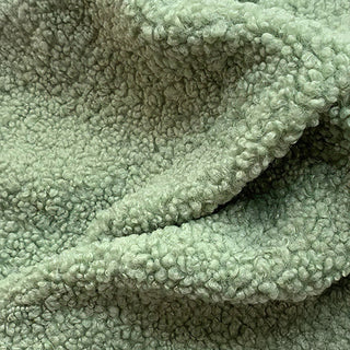 Close-up of green green teddy fabric showing gentle waves and plush texture.