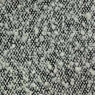 Close-up of grey tweed fabric showing marled texture with dark and light threads.