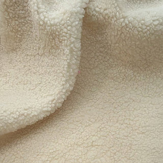 Close-up of ivory teddy fabric displaying soft, cozy surface with subtle draping.