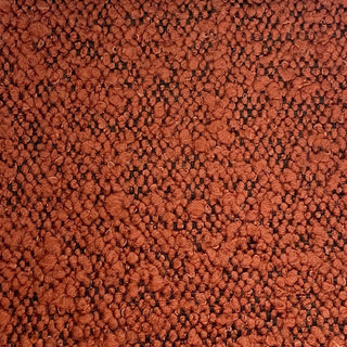 Close-up of rust tweed fabric displaying warm-toned weave with speckled pattern.